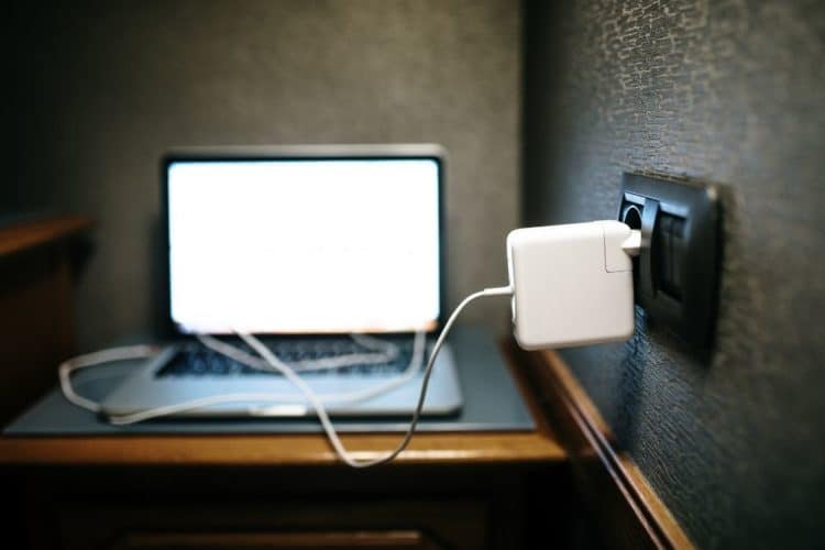 Ein Laptop wird über ein USB-Netzteil aufgeladen