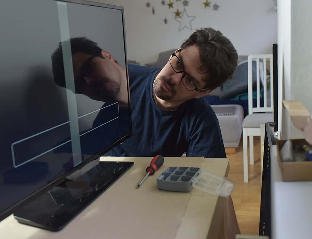 Ein Typ repariert einen schwarzen Bildschirmmonitor